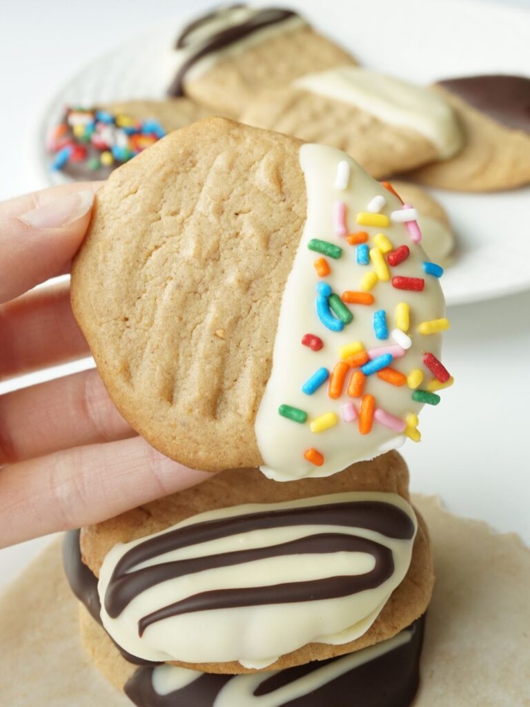 hand holding a keto peanut butter cookie with more cookies in the background