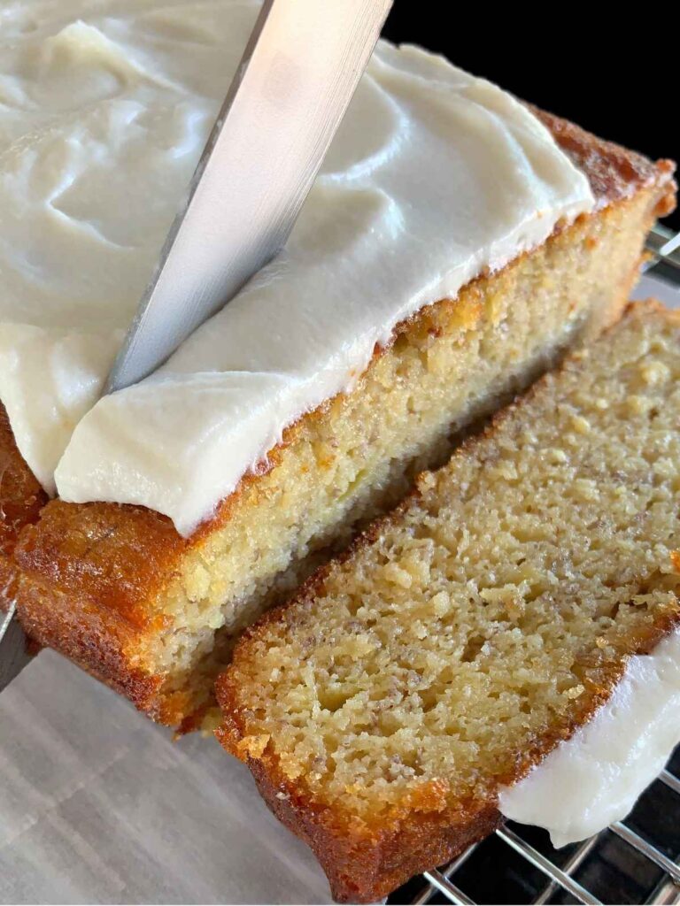 keto banana bread being sliced with a knife