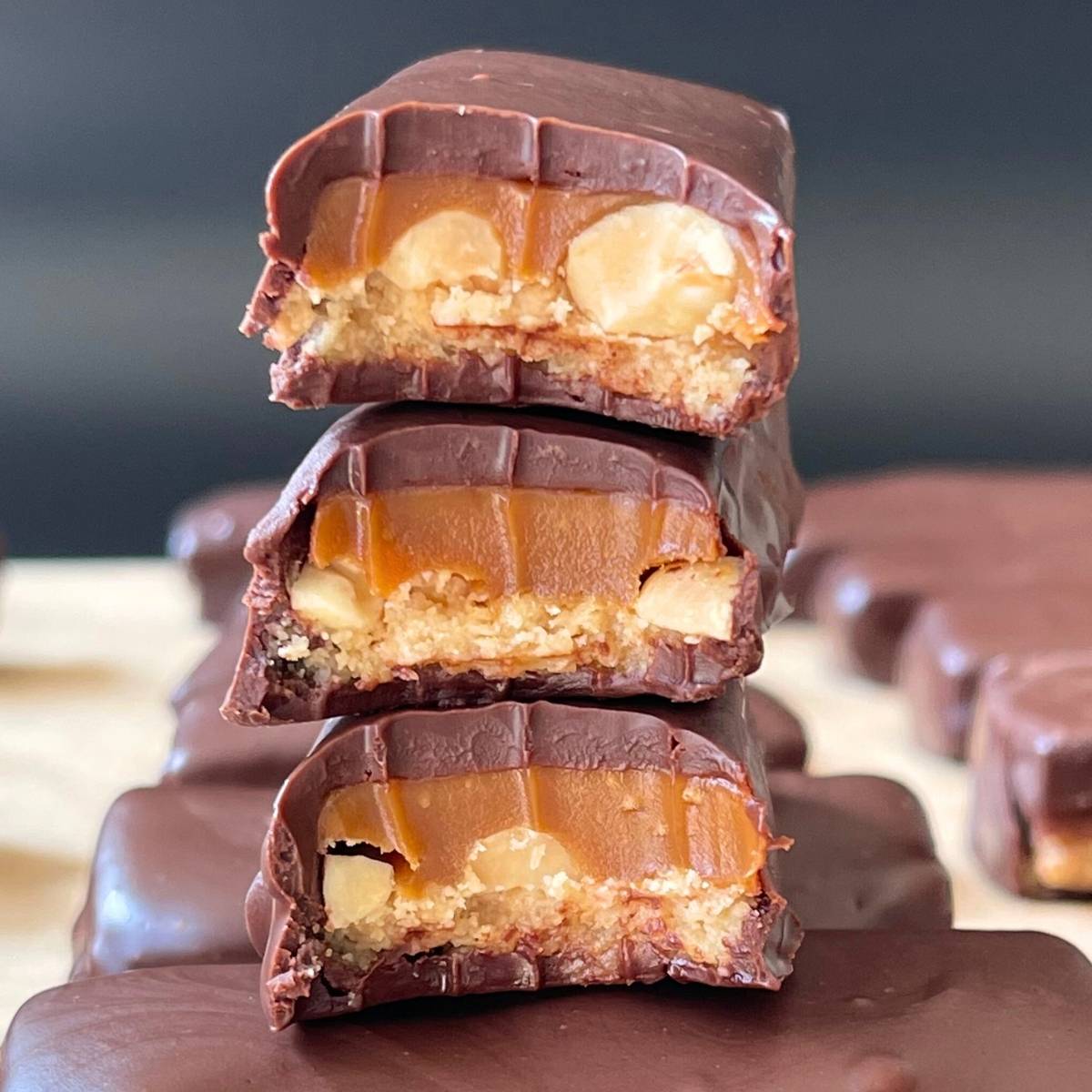 keto snickers bars with bites taken out and stacked on top of each other