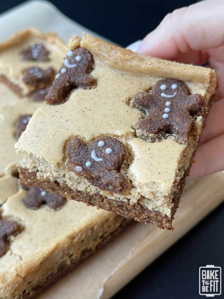 a hand holding a keto gingerbread cheesecake bar