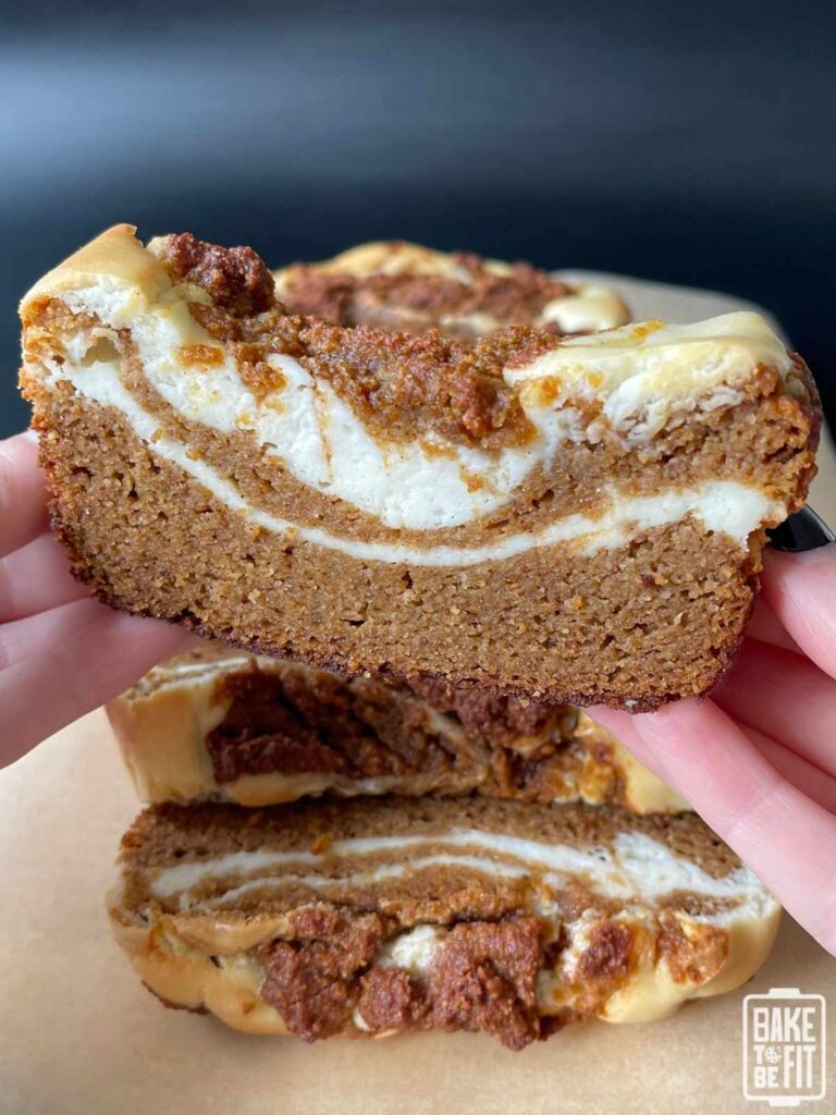 a hand holding a slice of keto pumpkin cream cheese bread