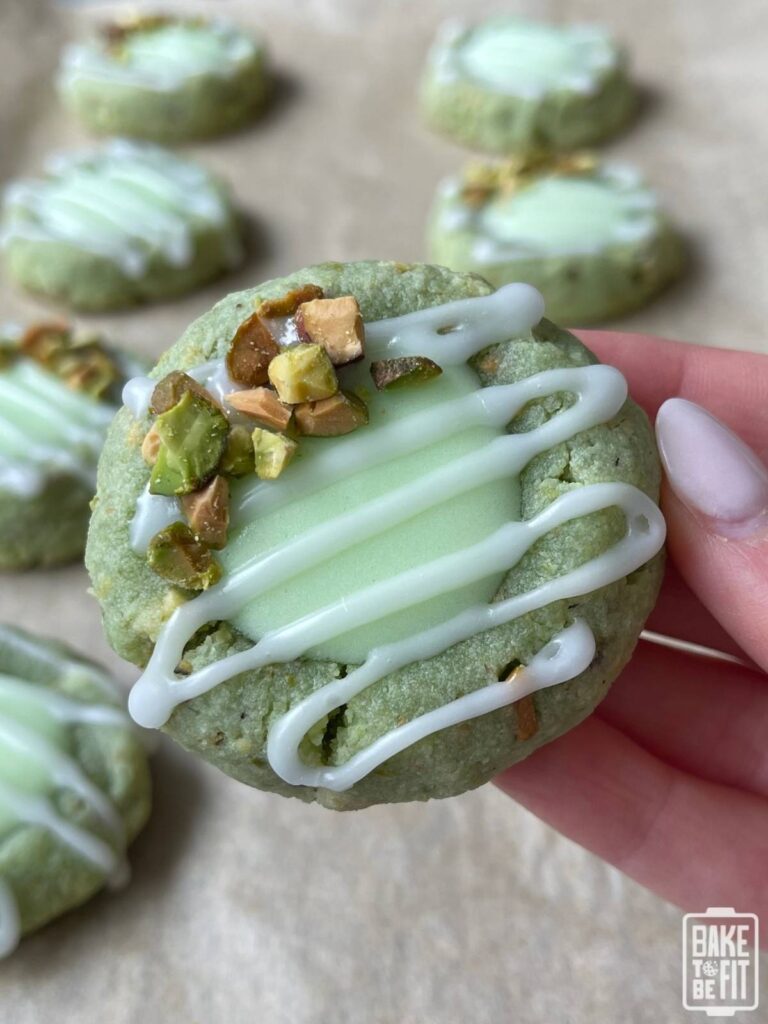 a hand holding a keto pistachio thumbprint cookie
